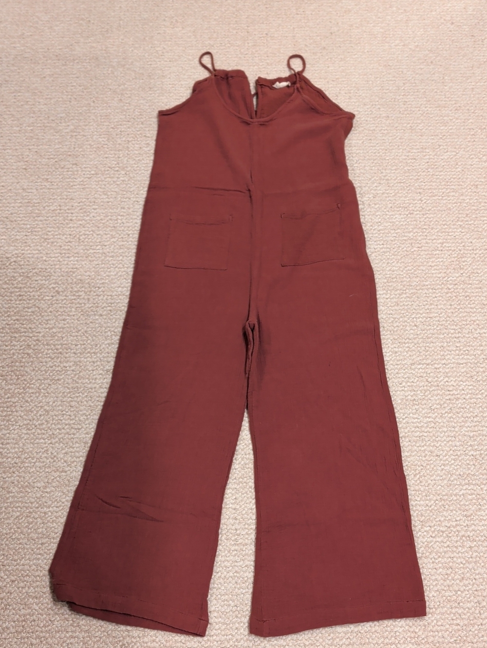 Sleeveless Wide-Leg Jumpsuit in A Rust Color.